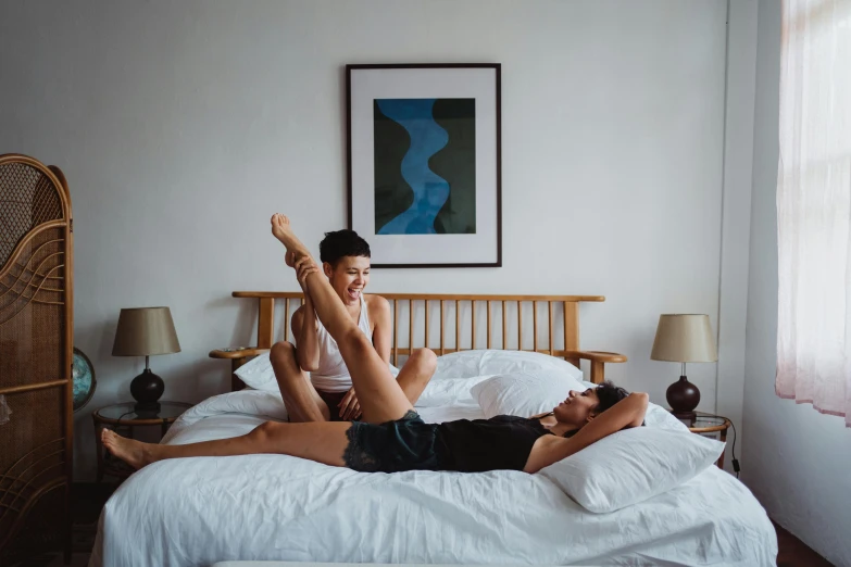 two people sitting on the bed and looking into each others eyes