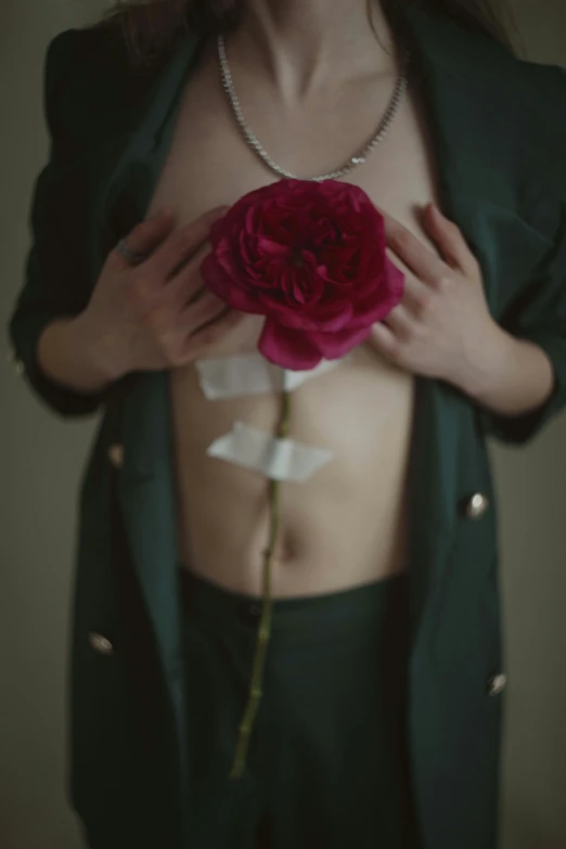 a girl in green jacket with a rose in her hand