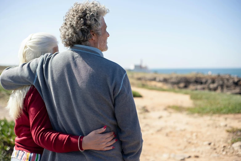 man and woman hugging each other near the ocean