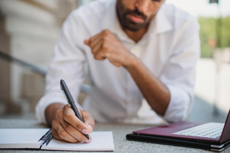 a man is sitting at the table and writing