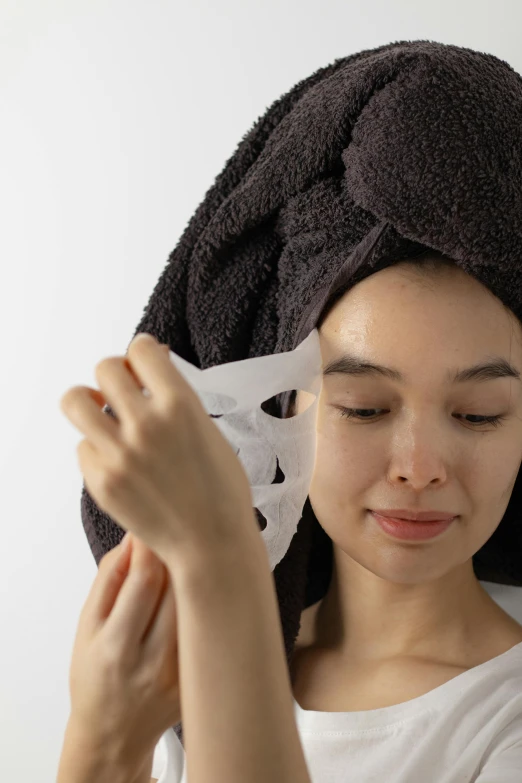 a woman holding up a hair towel over her head