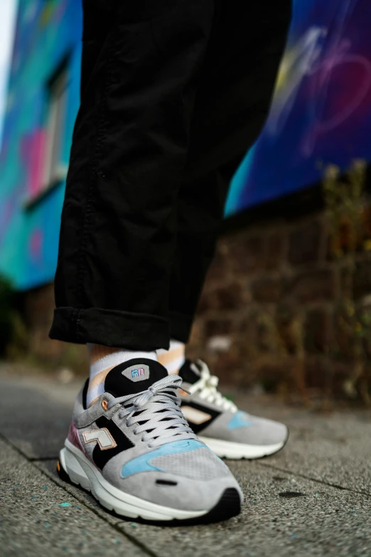 feet and legs of a man with blue and gray sneakers on