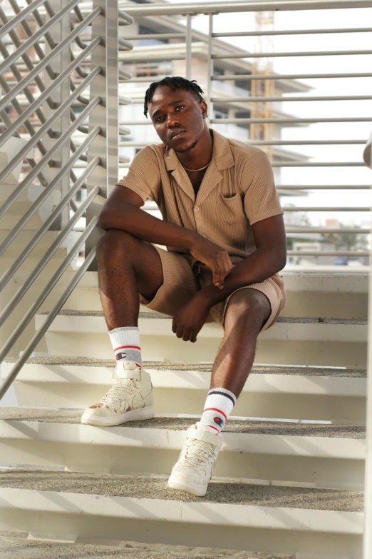 a man is sitting down and posing for the camera