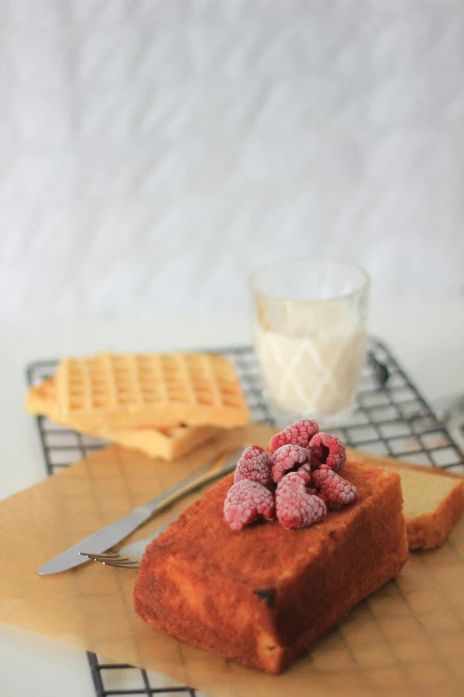 a piece of bread on a table with raspberries