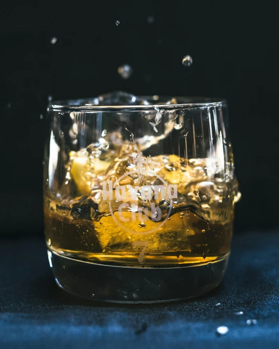 a glass with water and ice cubes on the table