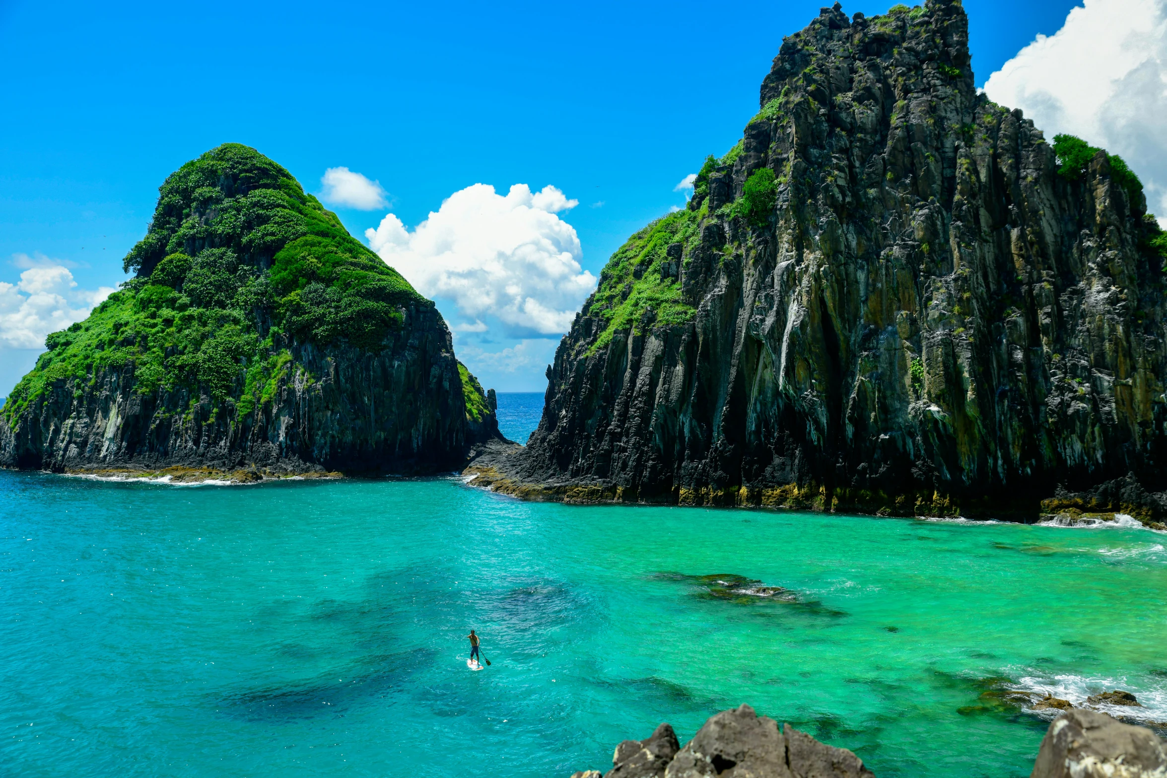 a group of rock formations surrounded by turquoise water