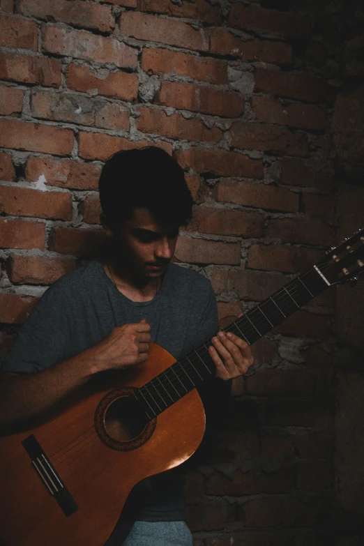 a man with beard playing an acoustic guitar