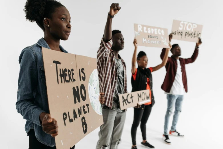 the group of protesters is posing holding signs