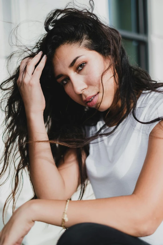 a young woman sitting on the ground posing for a po