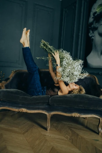 a woman lying on a bed with a bunch of flowers in her hand