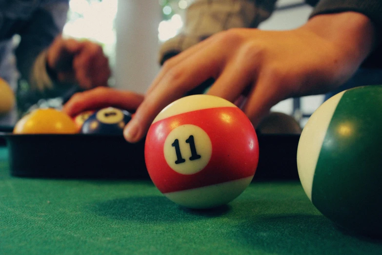 person selecting pool balls from a collection of others