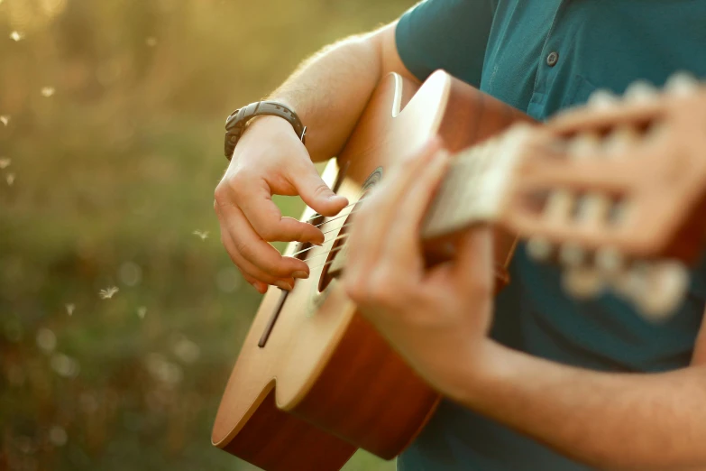 man wearing ring plays on his hand while holding a guitar