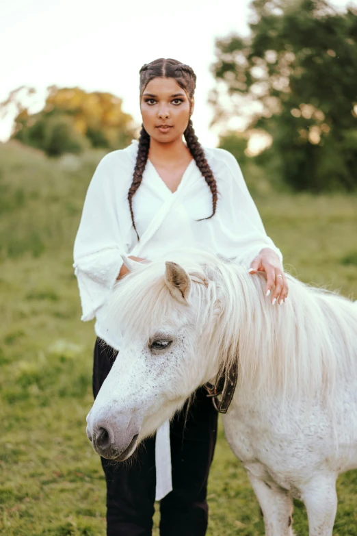 a woman with ids standing next to a horse