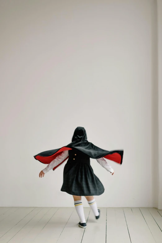 a woman wearing a black and white cape is running