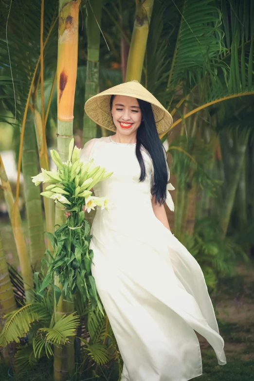 a girl poses with her bamboo tree for a po