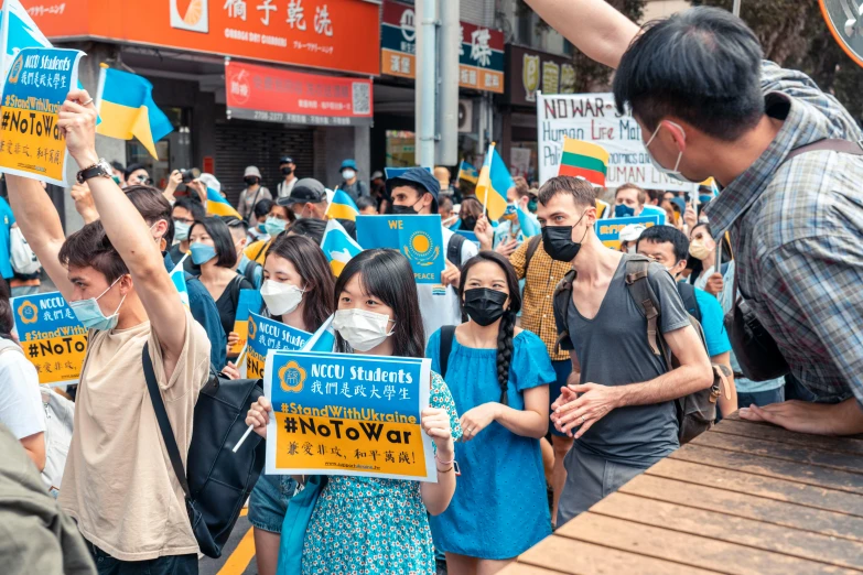 a crowd of people are standing around and protesting