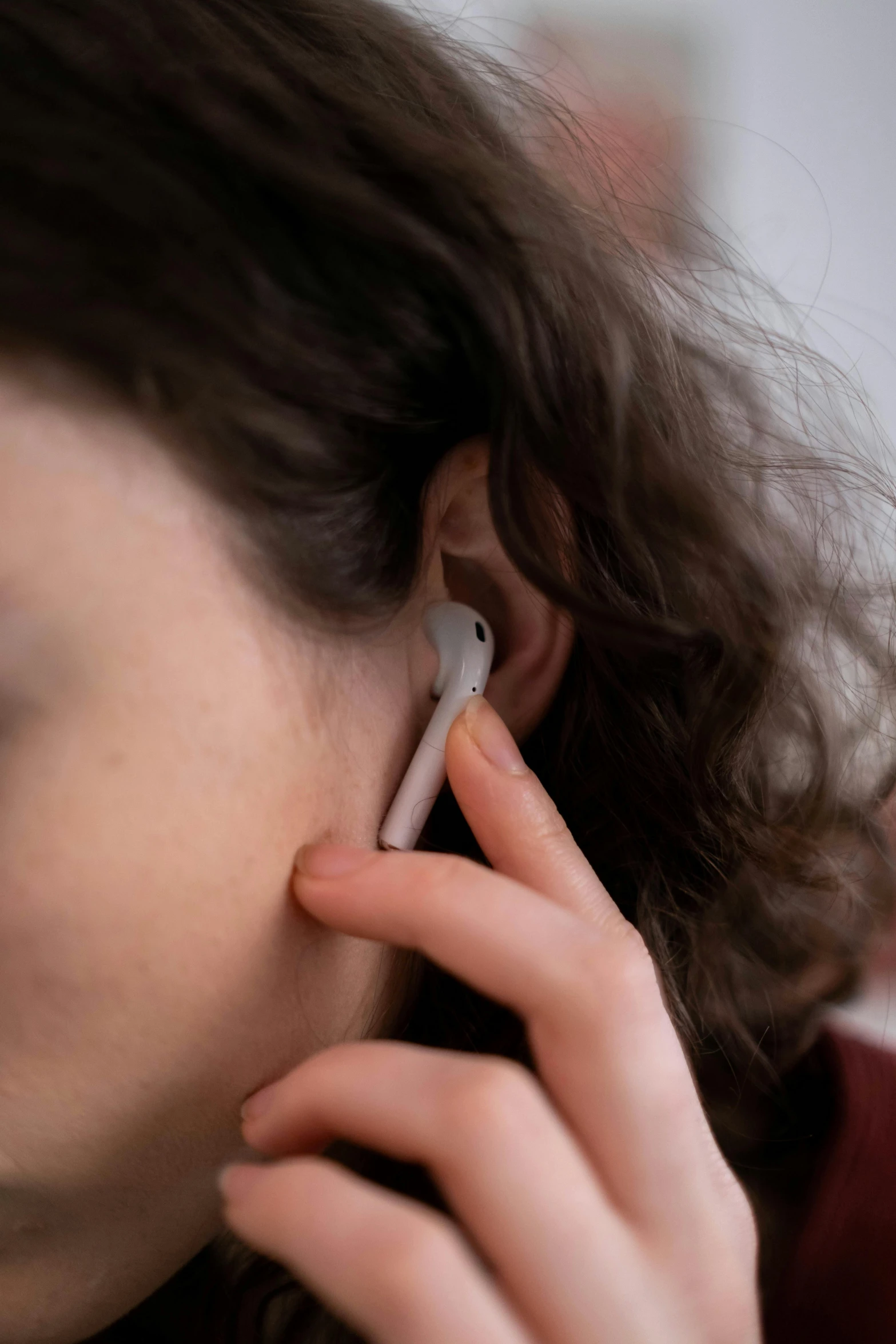 the woman's ear has a cell phone attached to it