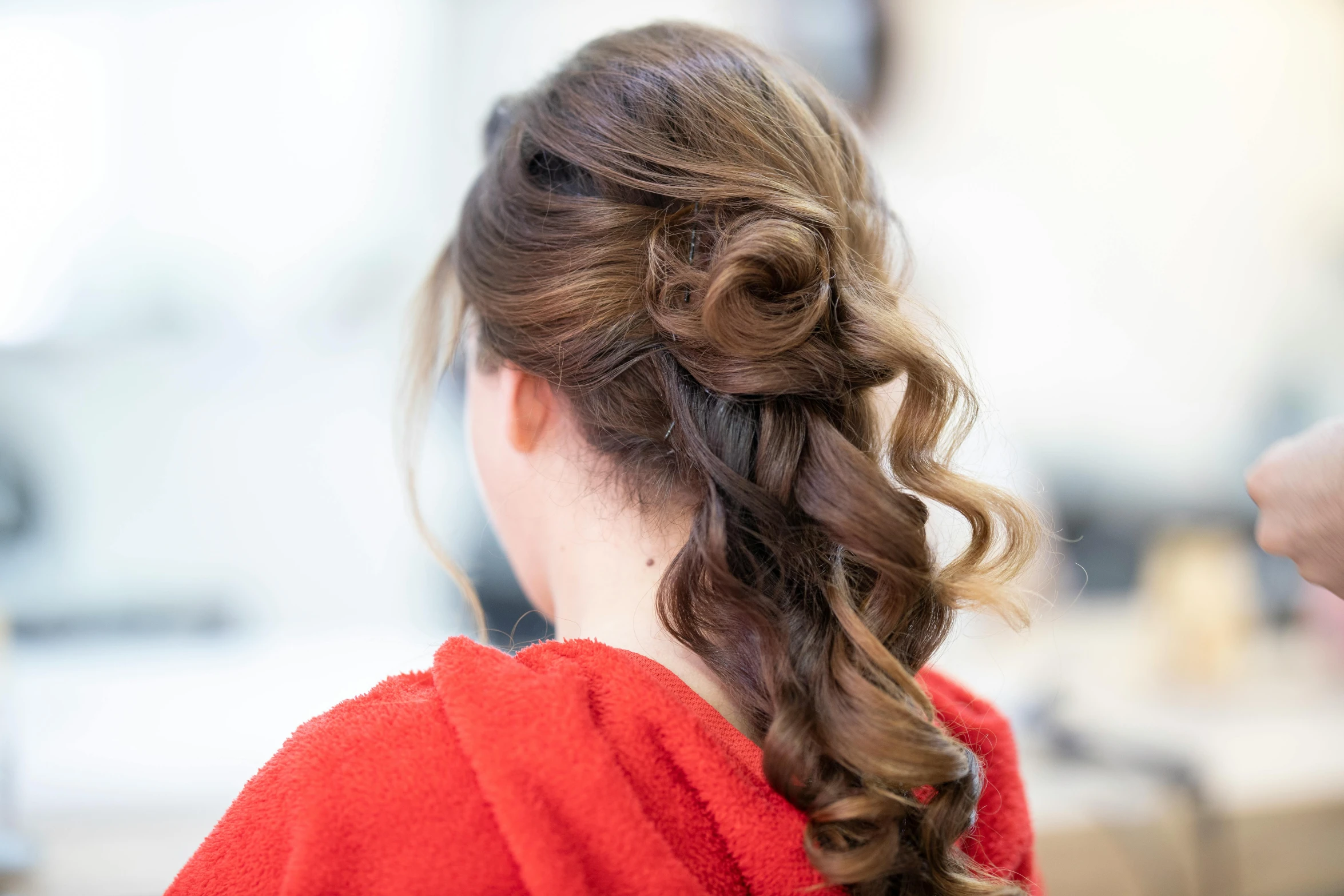 a close - up of the ponytail of a women's hair styled in side swept id