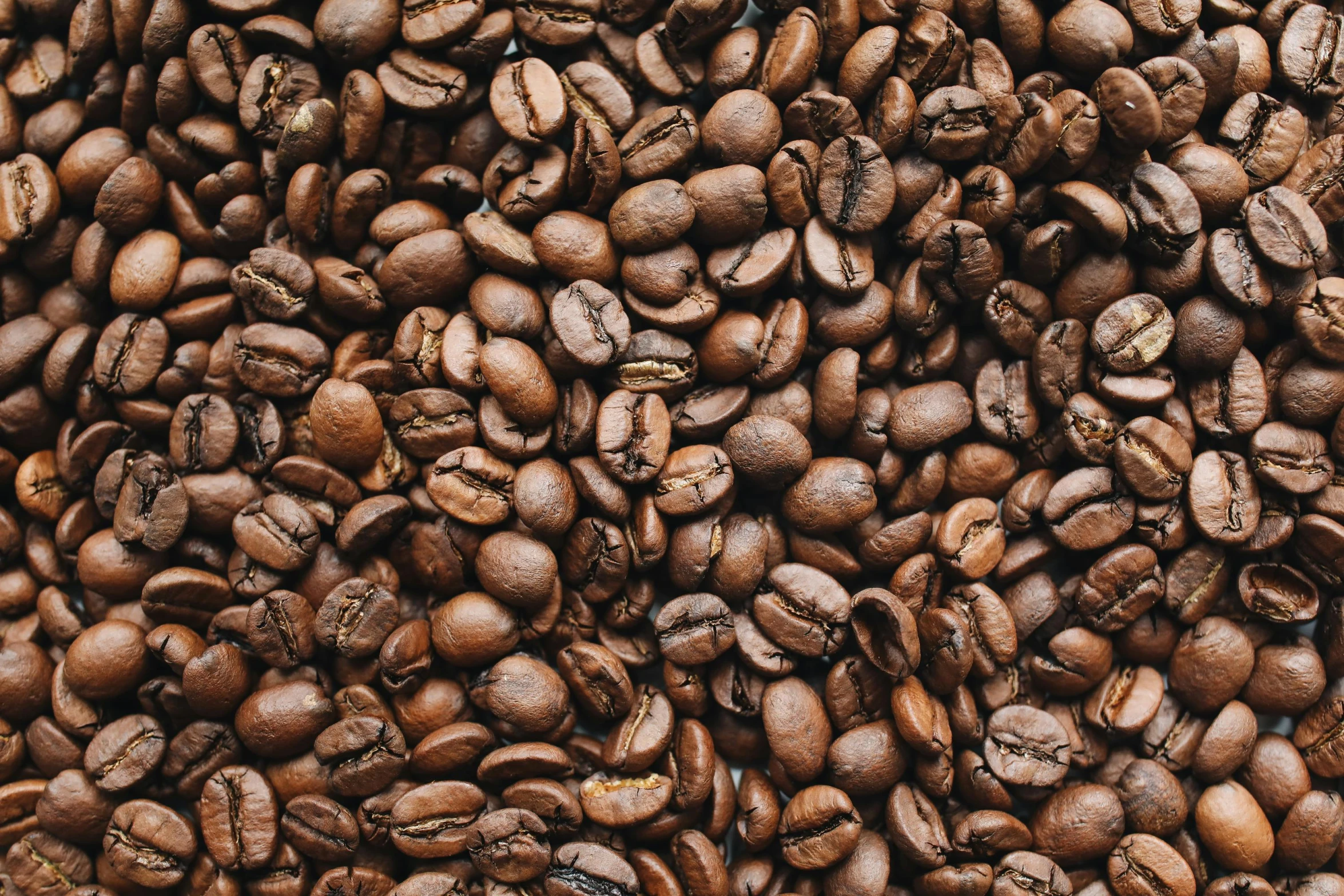 roasted coffee beans fill the surface of a pile