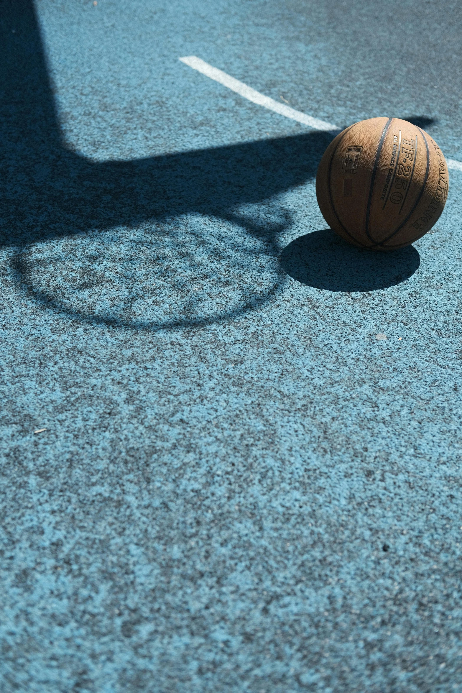 the shadow of a ball and basketball on a court