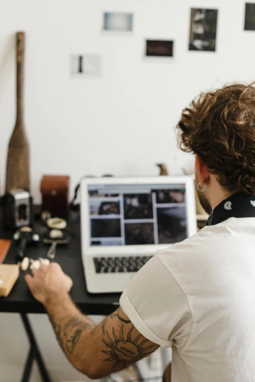 the man is doing soing on his computer at the desk