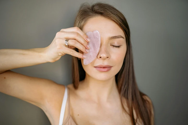 the young woman is holding the large piece of fruit up to her face