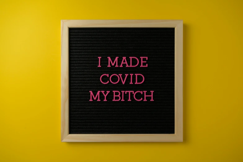 a neon pink sign reads i made covidd my bitch