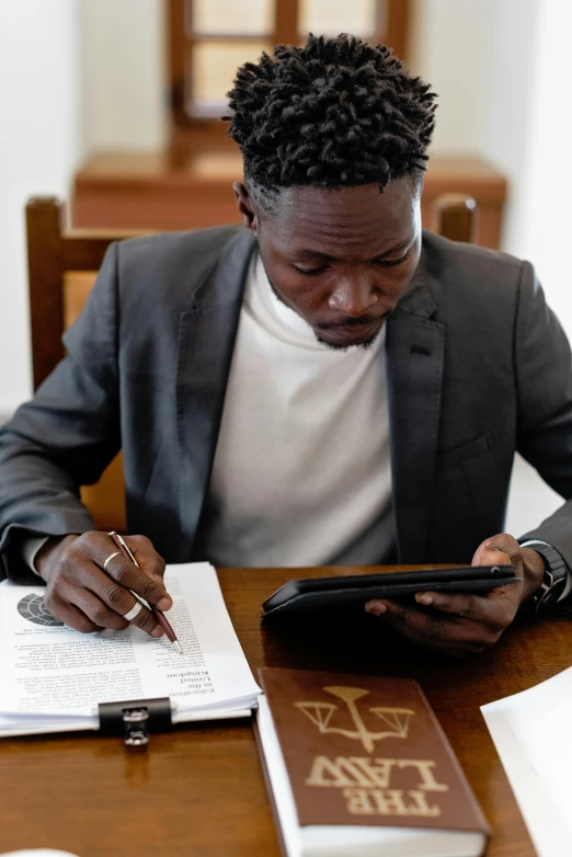 the man is holding a pen and using a small electronic device