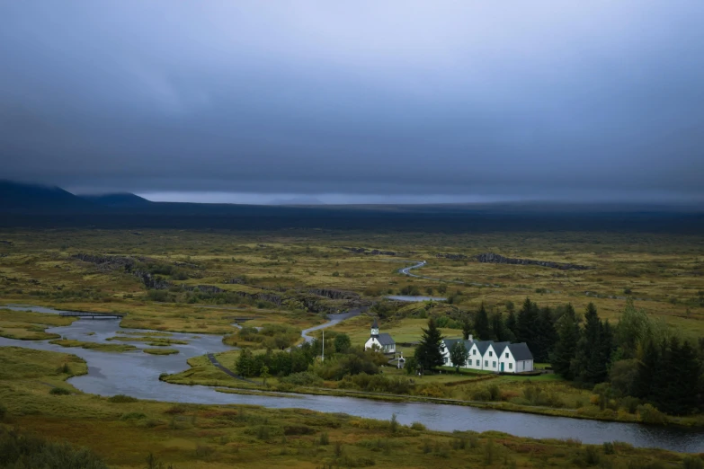 a long exposure s of the house on the corner of a pond, and mountain range in the distance