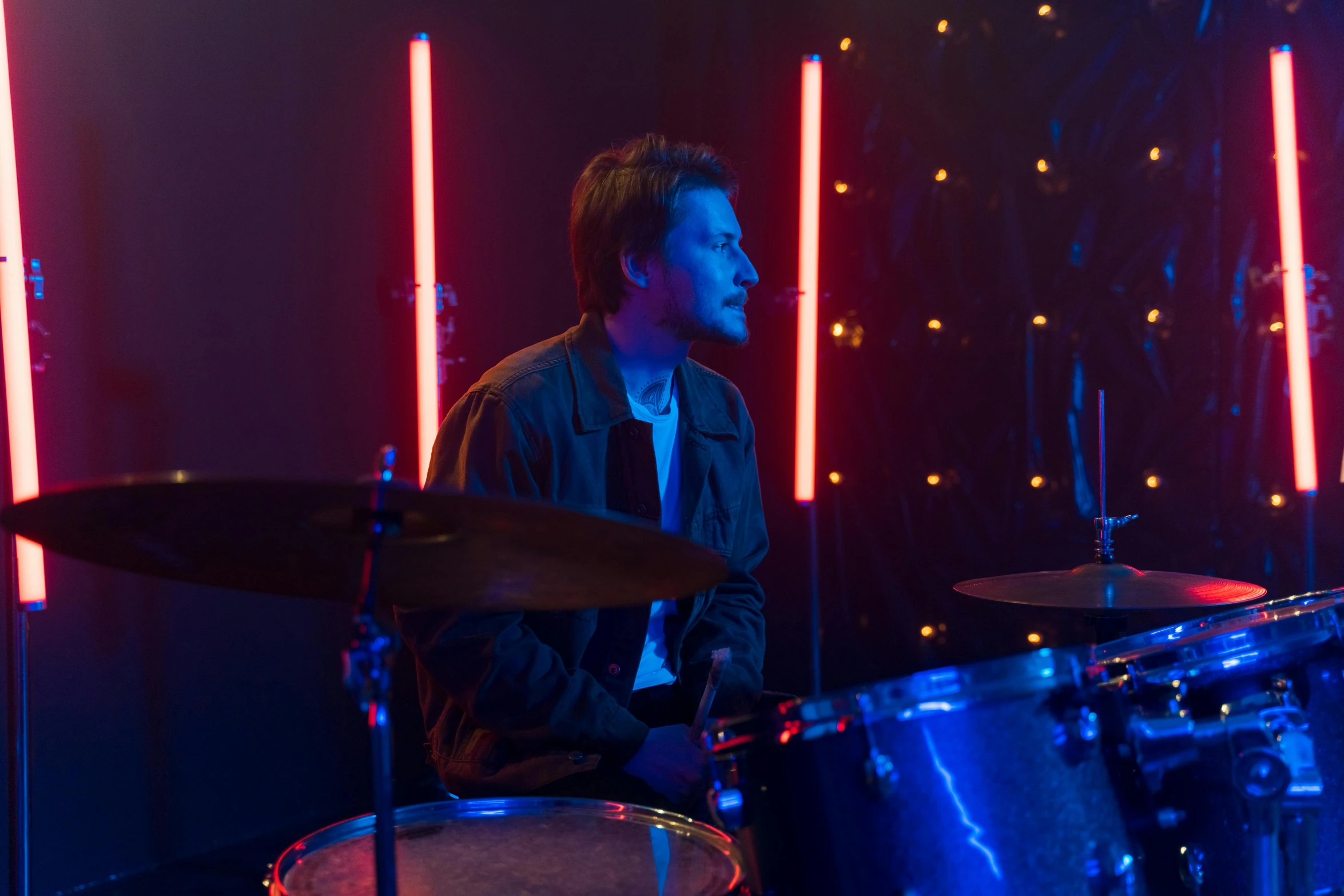 a man plays on drums in front of a dark background