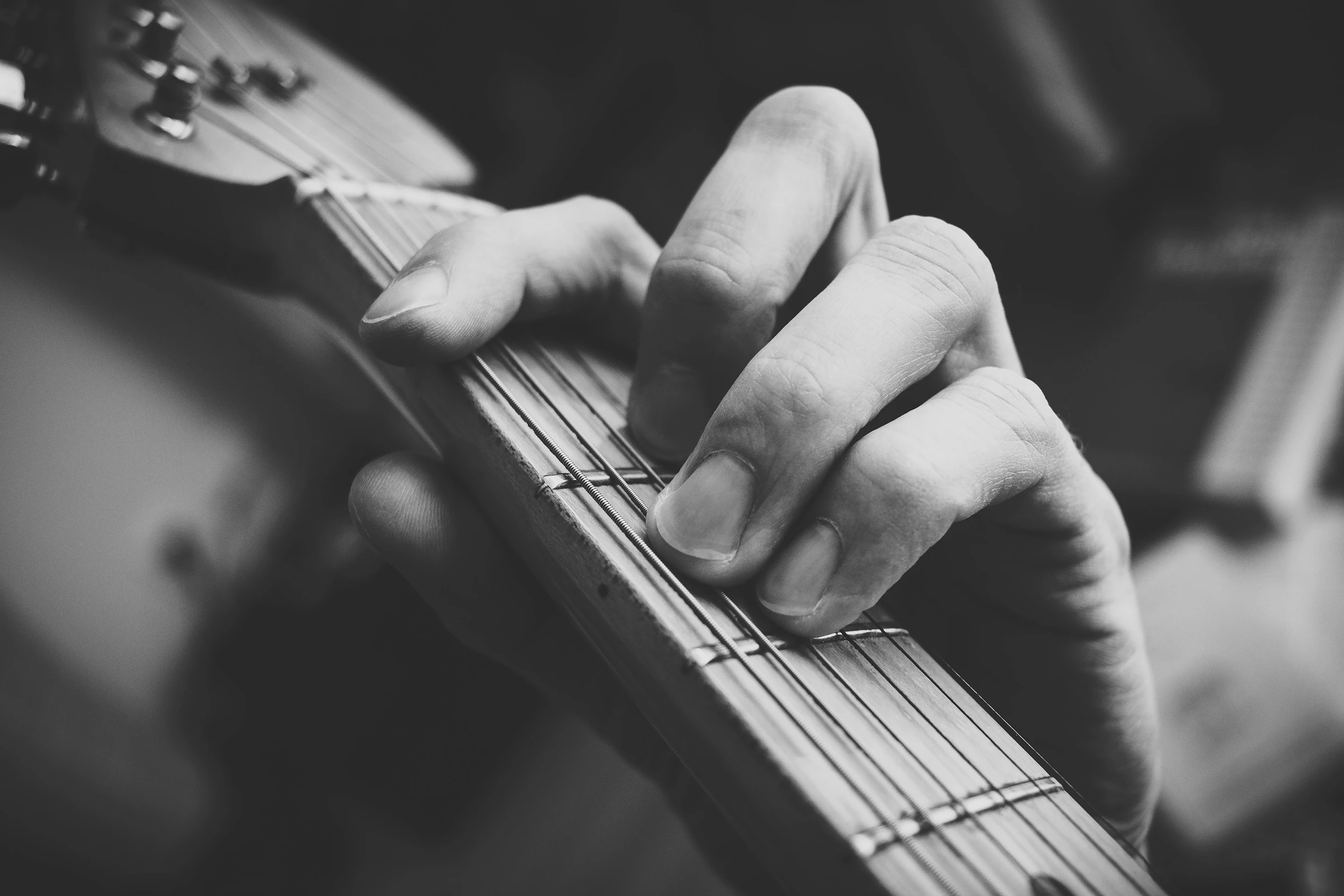 a person with long nails holding a bass guitar
