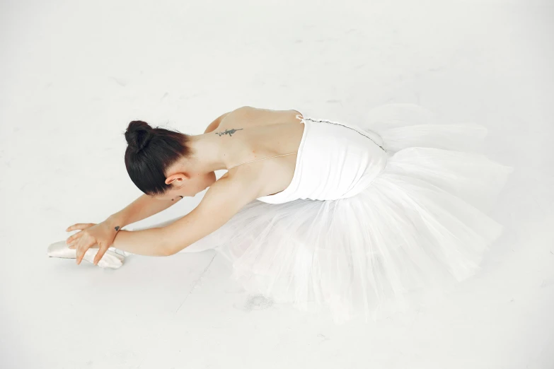 woman dressed as a ballerina laying on the ground