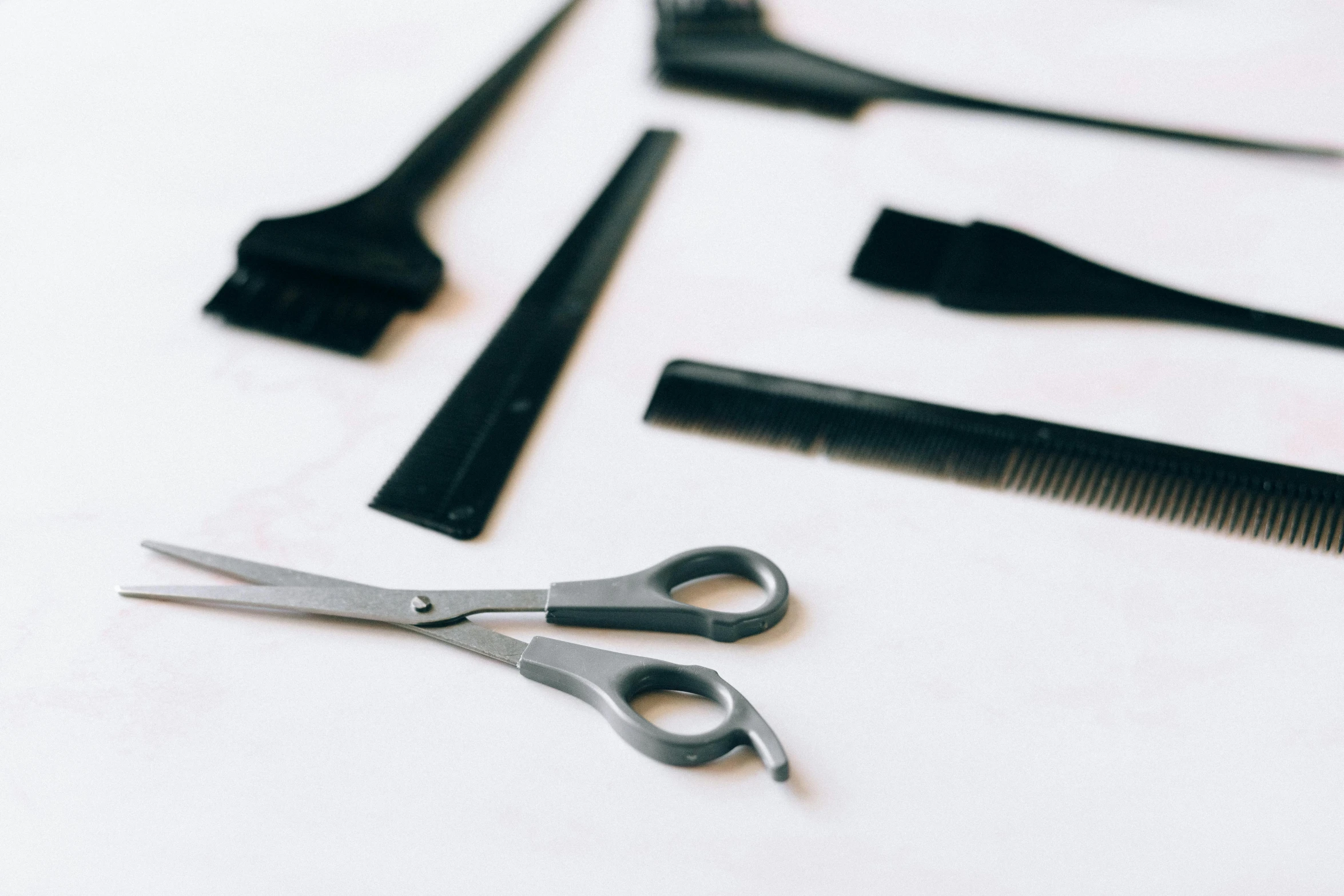 scissors, combs, and other items placed on white fabric