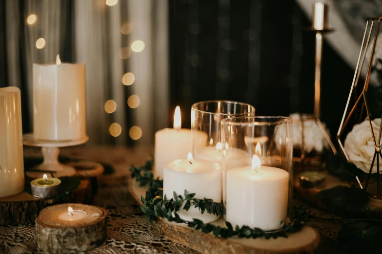 a bunch of white candles sitting on top of a table