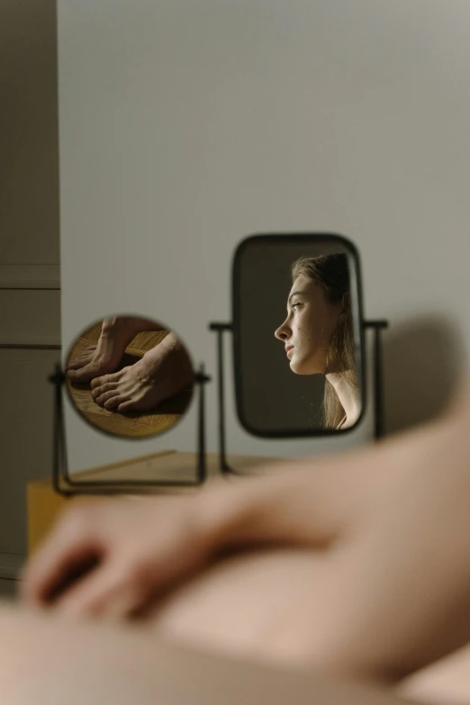 a woman looks at herself in the mirror