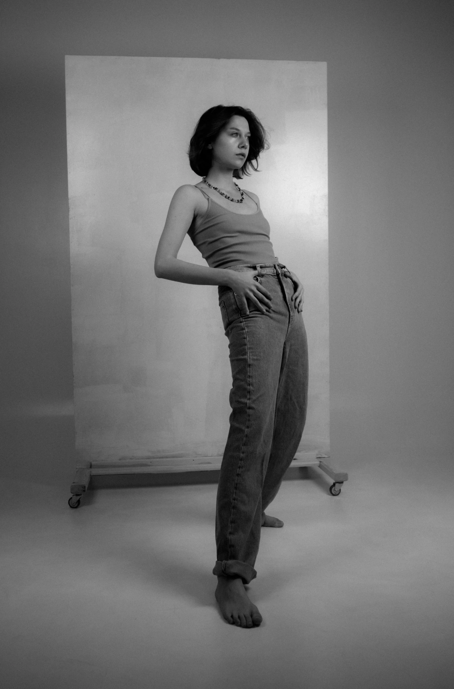 a woman in grey pants standing in a white room