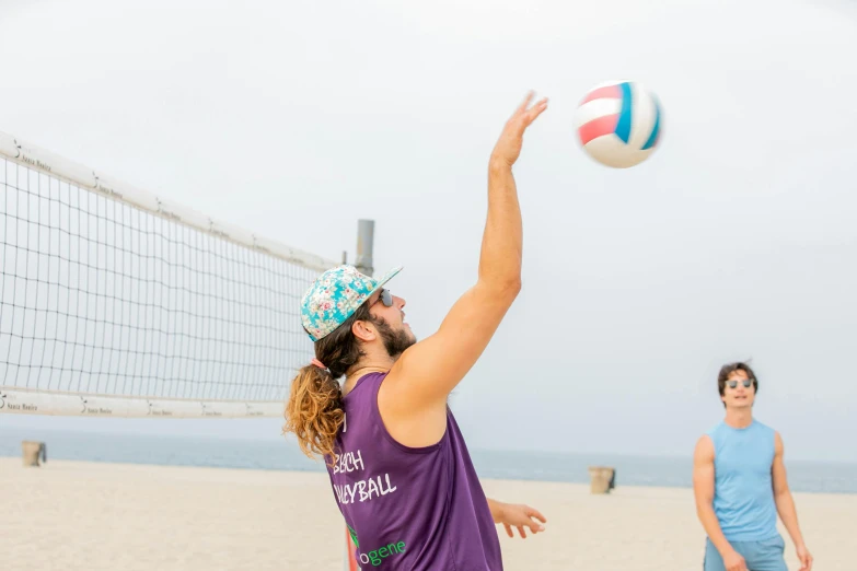 two women are playing volleyball on the beach