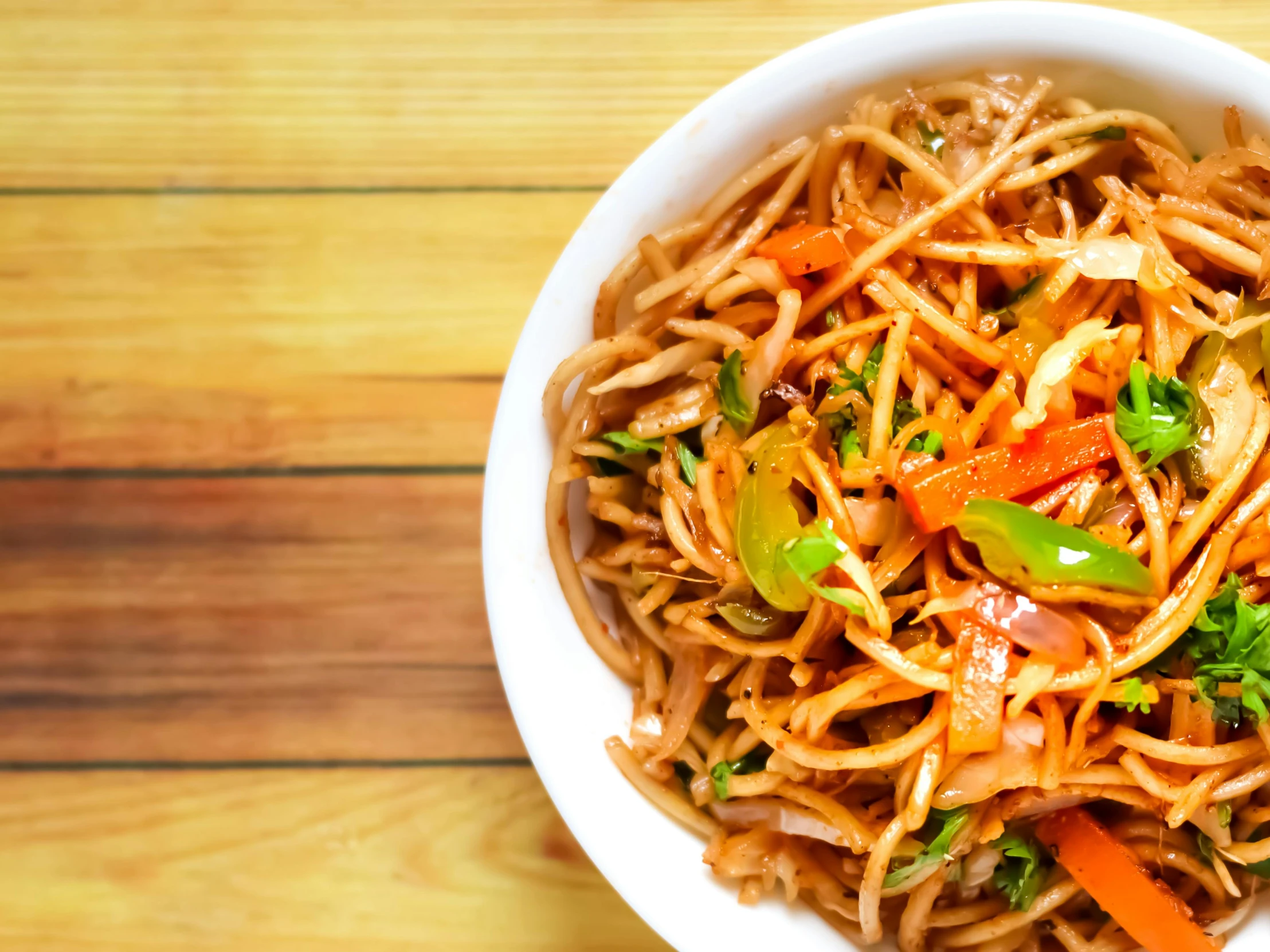 a bowl full of noodles and vegetables on a table