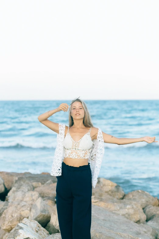 a woman in cropped top on the beach near the water