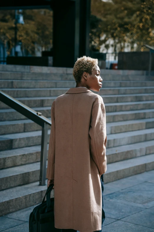 a woman is holding her suitcase looking off into the distance