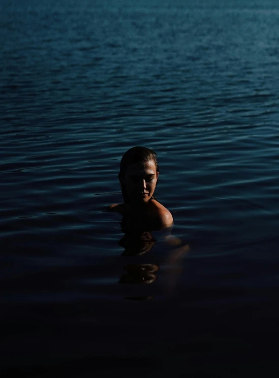 a boy is swimming in the water and has his head submerged