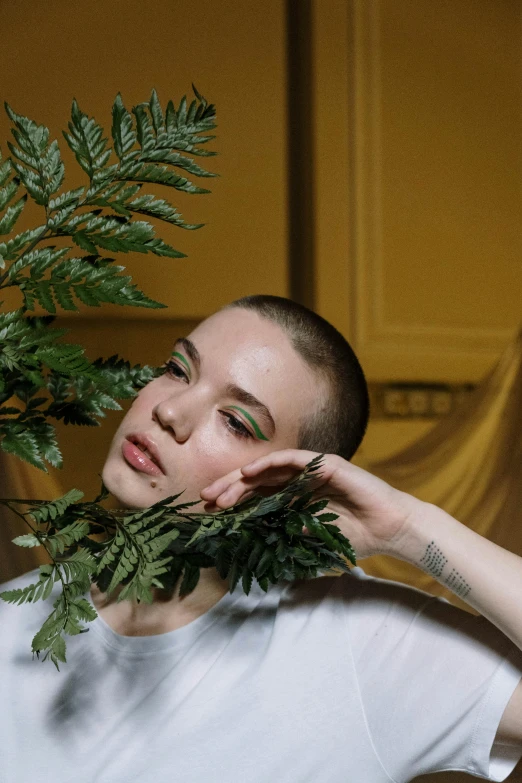the young woman is posing with some fern leaves
