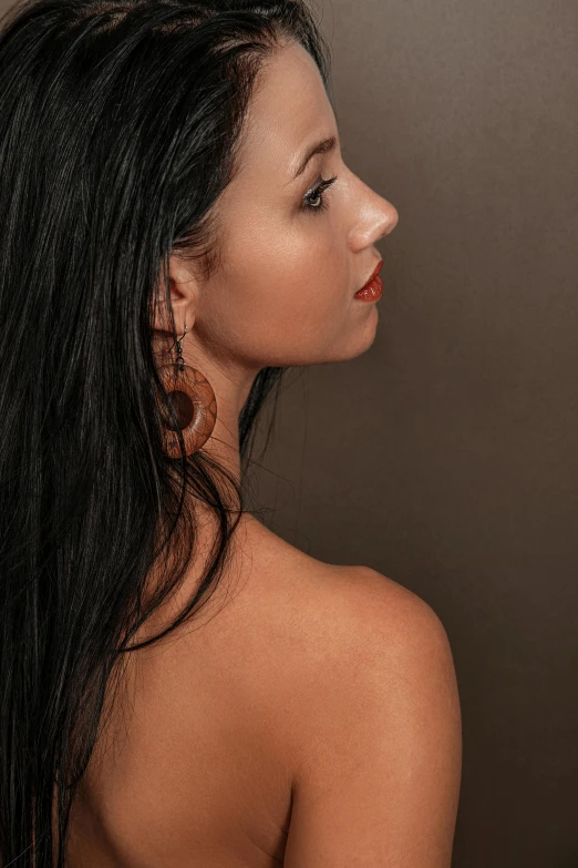 a woman with brown earrings posing for a po