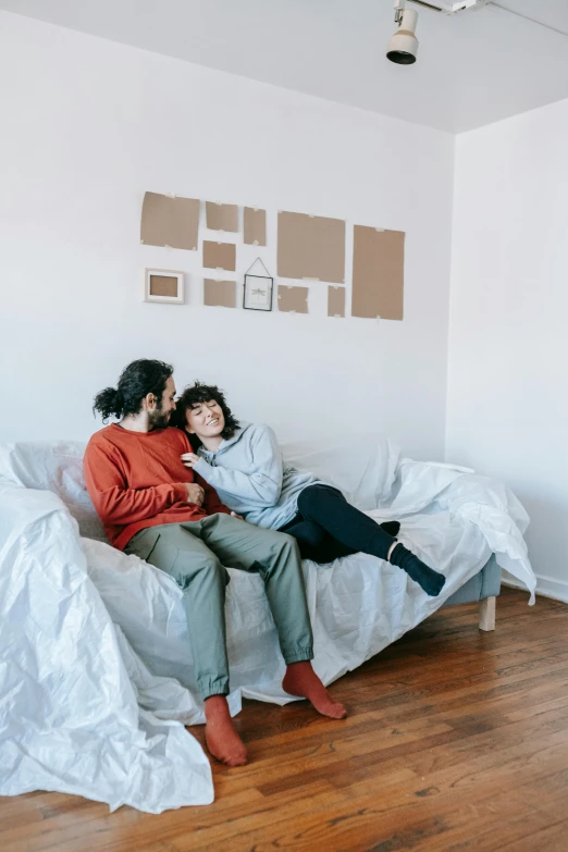 two people on a bed in the corner of a room