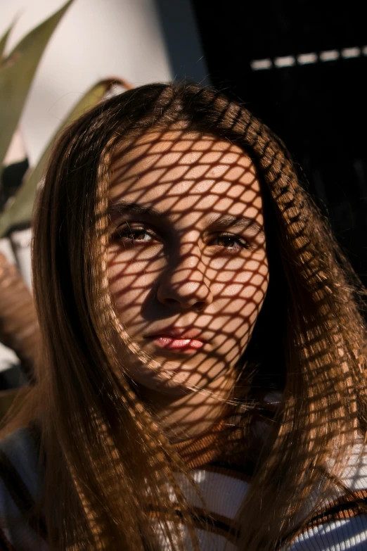 a woman's face and face behind a net