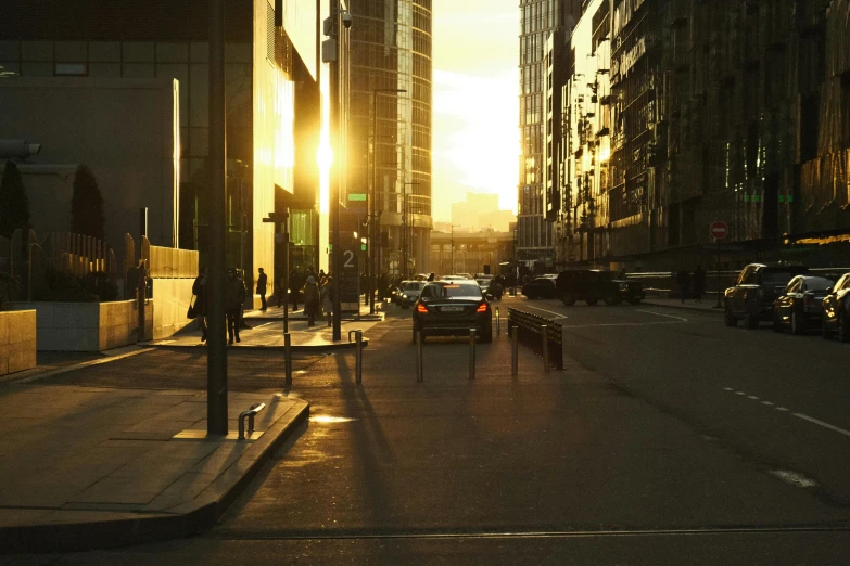 cars are driving down a city street with buildings in the background