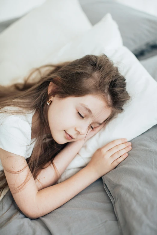 a girl is laying down on her bed in the dark