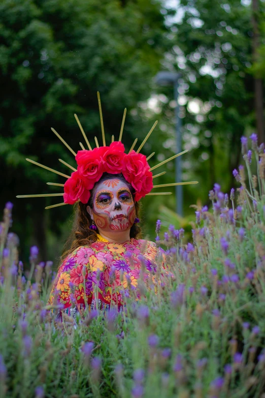 a woman with white make up and flowers on her head in lavender