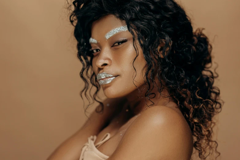 a beautiful woman posing for a picture with silver makeup