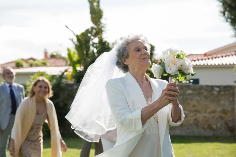 a bride is walking with her family down the street